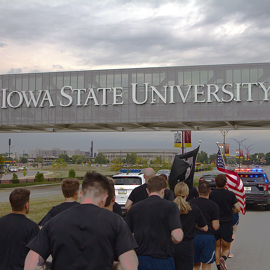 Group of cadets running in the POW-MIA run underneath a bridge that says Iowa State University